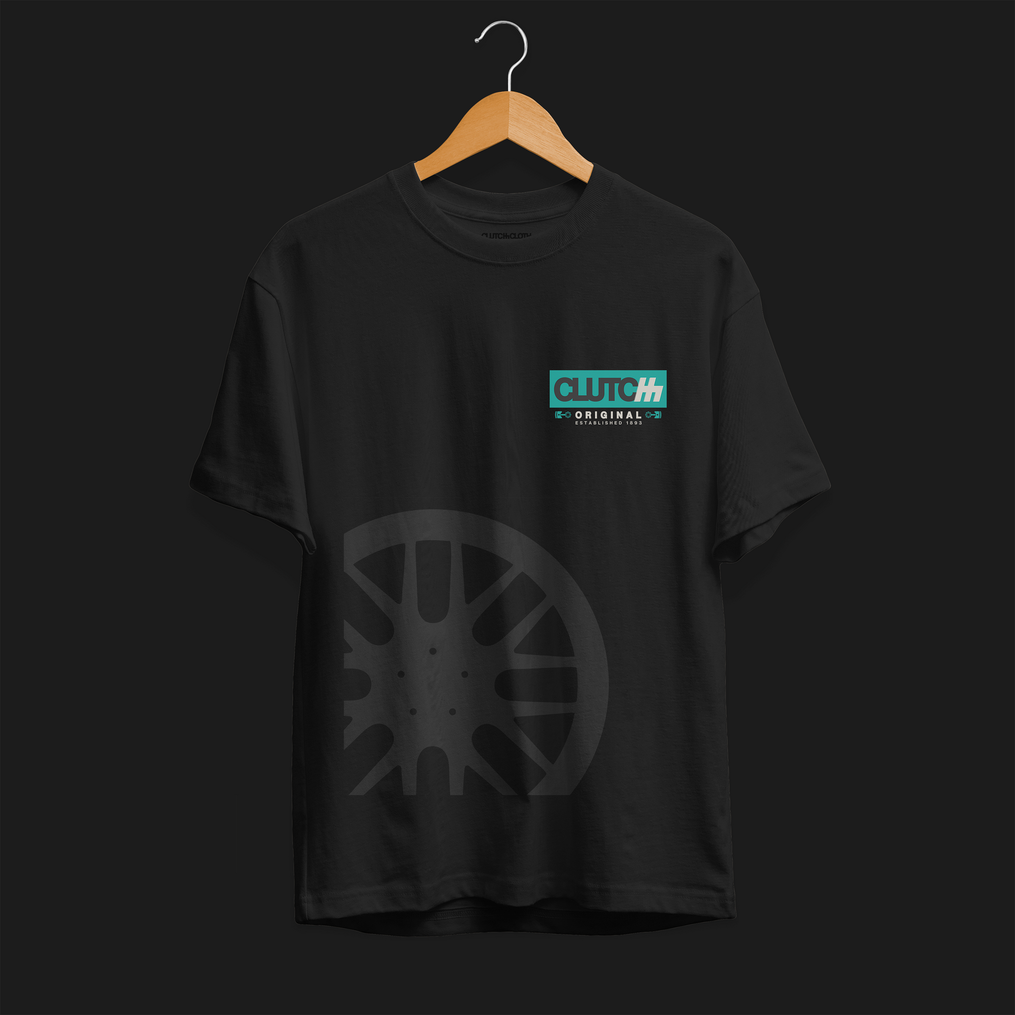 Clutch Original Est 1983 Automotive Graphic T-Shirt – Front View Black tee with Clutch Original logo on the chest and a subtle wheel graphic. Perfect for car enthusiasts and motorsport fans.