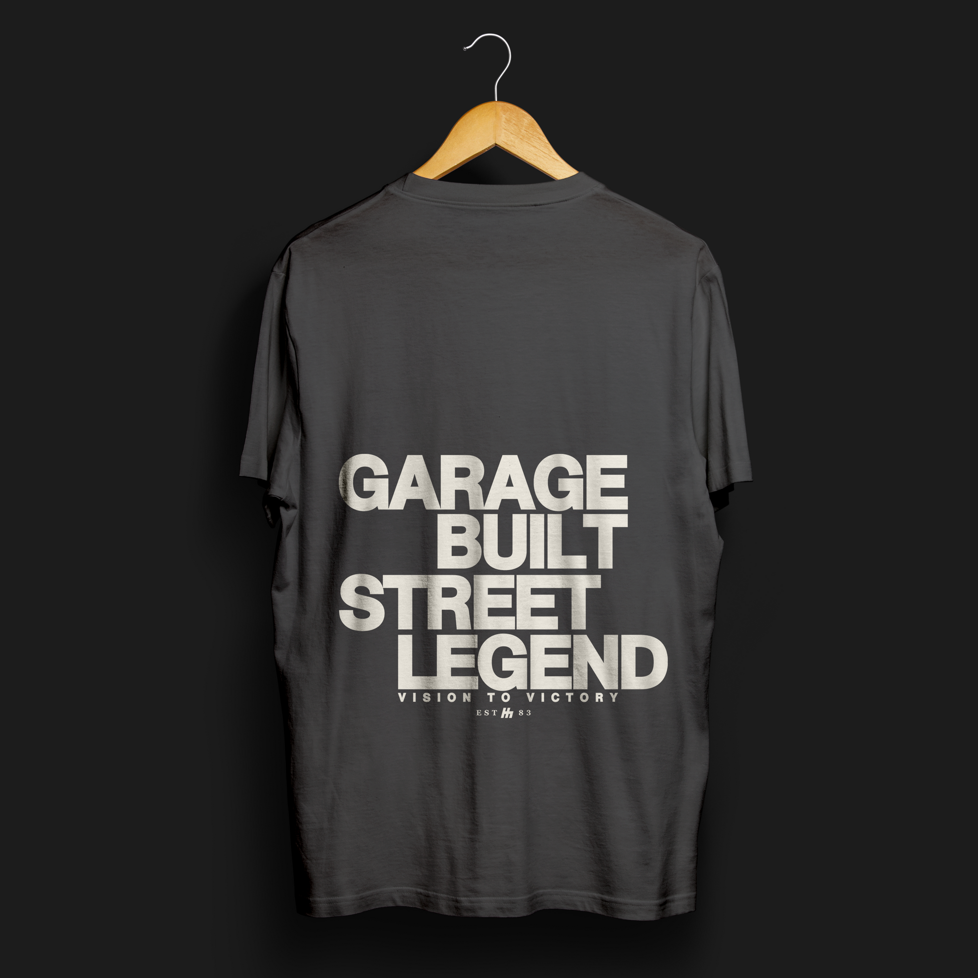 Garage Built Street Legend Automotive Graphic T-Shirt – Charcoal black tee with bold "Garage Built Street Legend" text on the back. Perfect for car enthusiasts and motorsport fans.