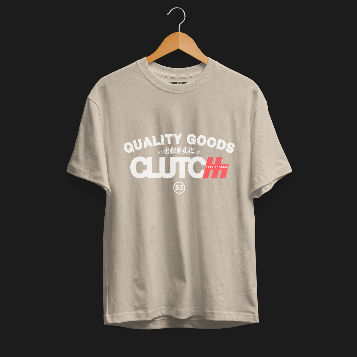 Quality Goods Car Culture 83 Automotive Graphic T-Shirt – Beige tee front view with &quot;Quality Goods&quot; and &quot;Clutch Auto Apparel&quot; text, accented with Japanese characters and red highlights. Perfect gift for car enthusiasts and streetwear fans.