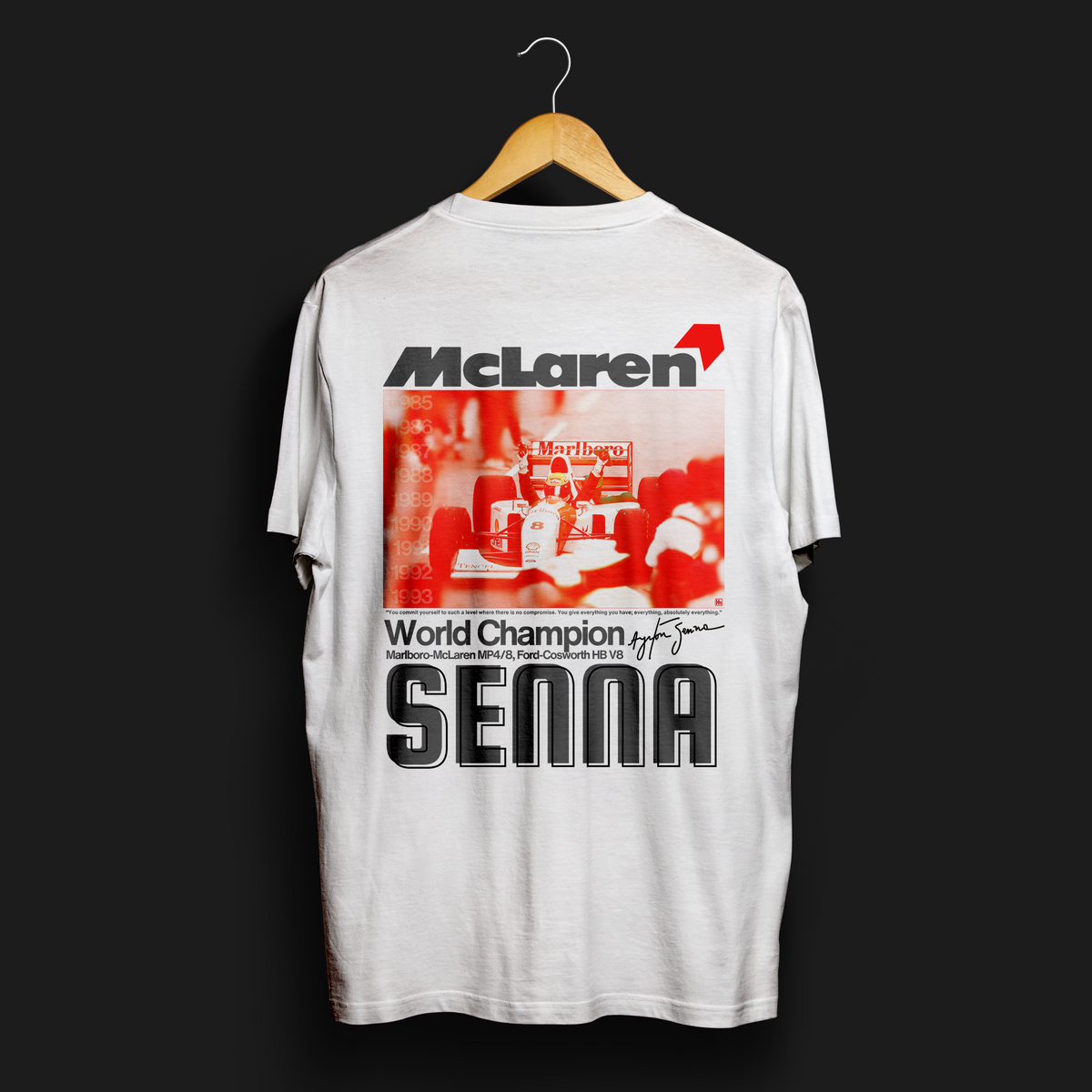 Senna - Give Everything Automotive Graphic T-Shirt – White tee featuring an iconic Ayrton Senna McLaren design with bold red and black text. Perfect for F1 fans and motorsport enthusiasts.